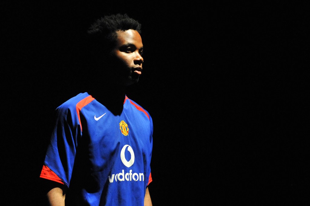 A young man stood half in shadow